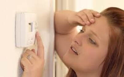 woman trying to fix thermostat