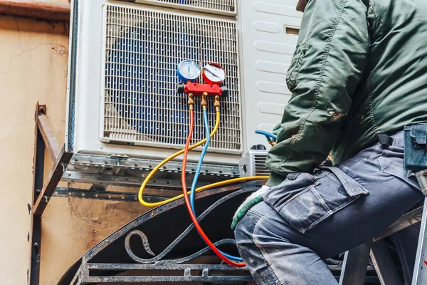HVAC technician repairing AC unit in Farmington Hills Michigan